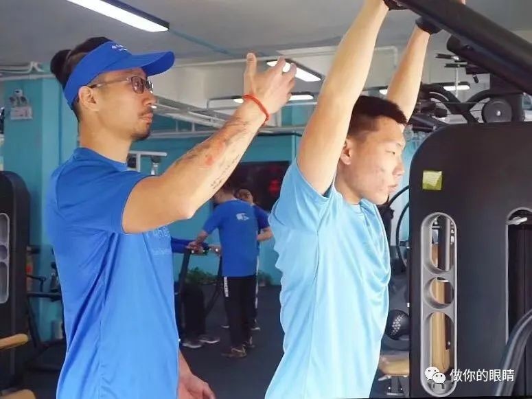 蓝睛灵视障小伙伴在倾听教练的健身解说和引导下做健身运动 Lanjingling members doing workout, guided by professional trainers